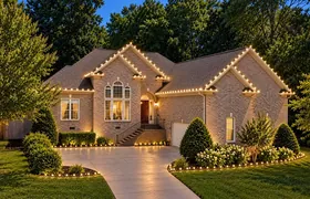 Design rendering: Gabled home with warm white roofline lights and illuminated landscaping